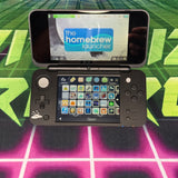 Handheld gaming console with homebrew launcher interface on a colorful background
